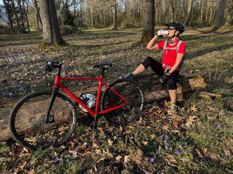 Radfahrerin macht Trinkpause im Wald